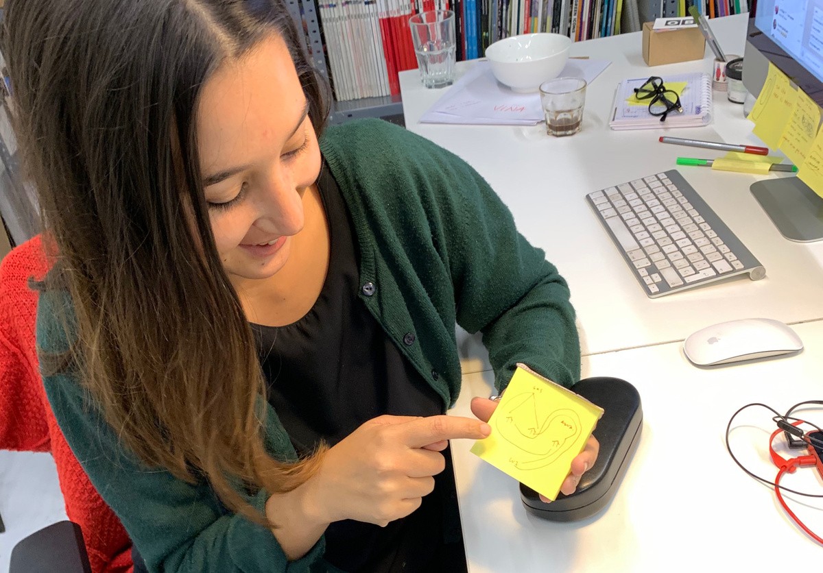 student pointing at post-it note