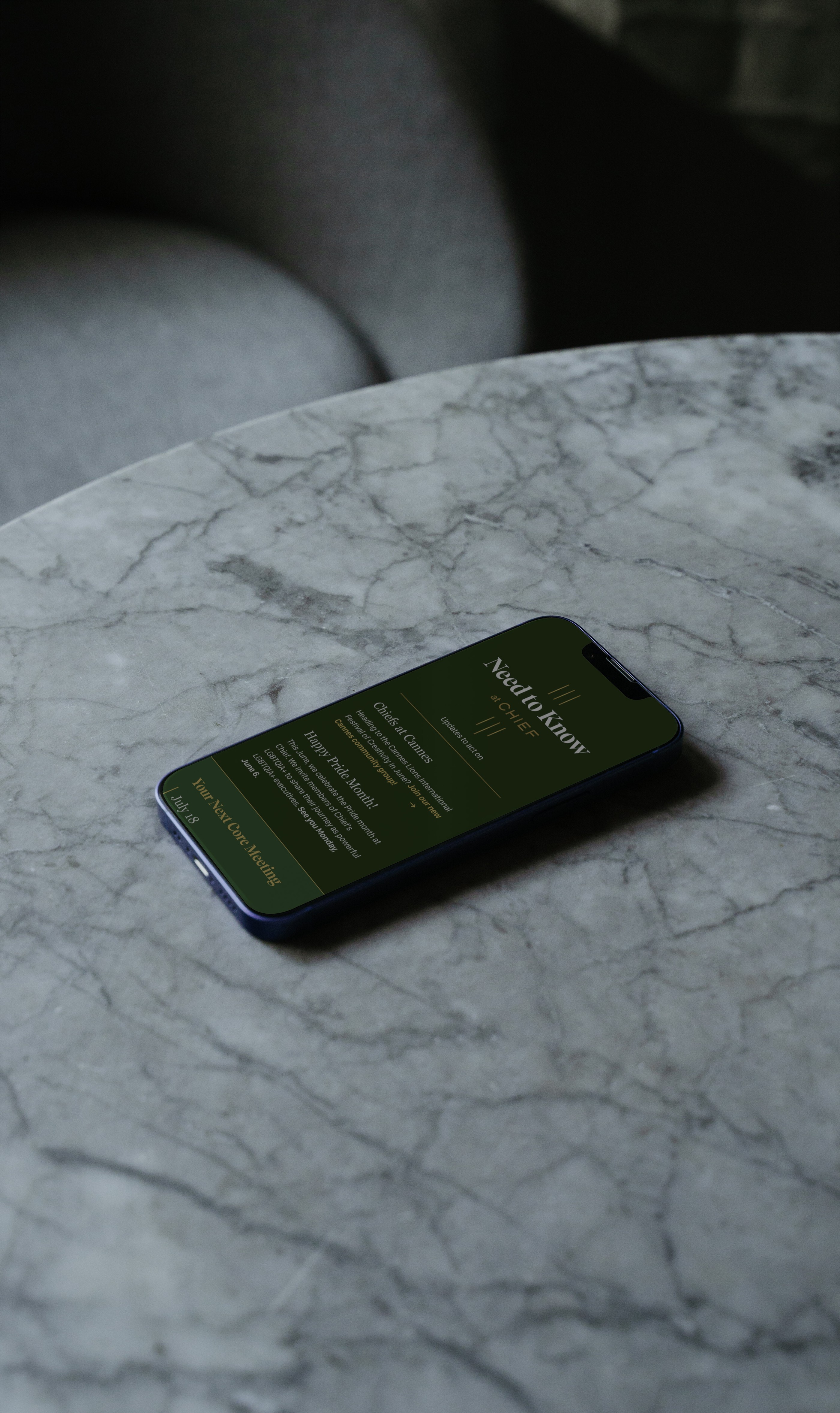A phone on top of a marble table with a landing page of Chief.